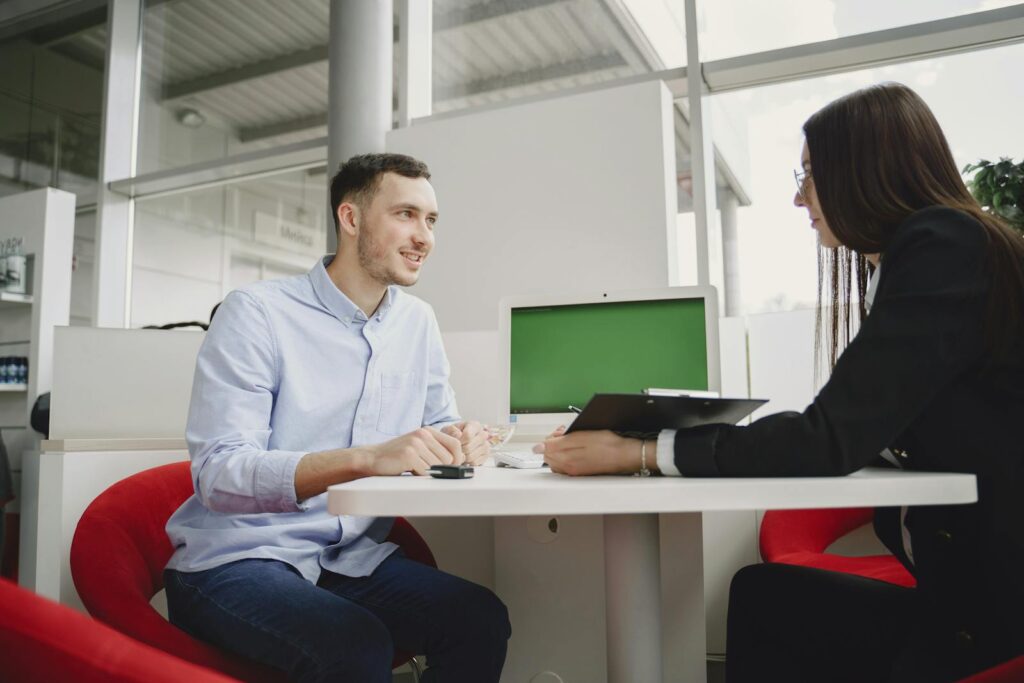 A man and woman engaged in a professional meeting at a modern office table.