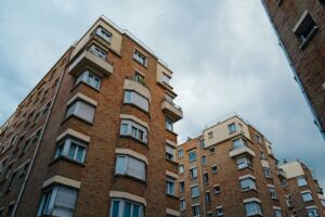 Urban brick apartment buildings under a cloudy sky, showcasing city living architecture.