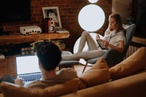 Relaxing evening at home with couple working and reading in cozy living room.